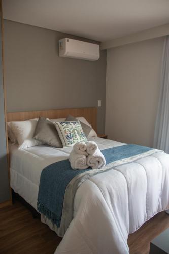 two stuffed animals sitting on top of a bed at Loft completo no Centro de Itaipava in Araras Petropolis