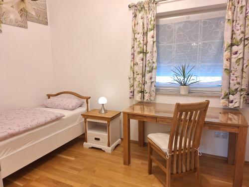 a bedroom with a desk and a bed and a window at modern und gemütlich in Linden