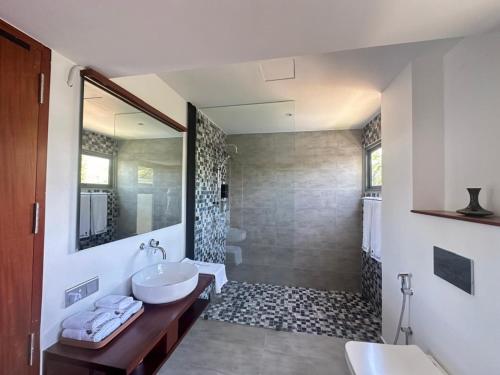 a bathroom with a sink and a toilet and a shower at BlackRoots Unawatuna in Unawatuna