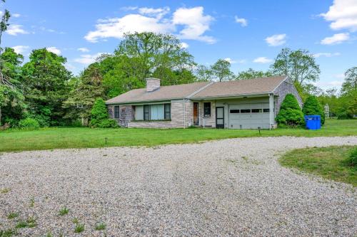 a house with a gravel driveway in front of it at Relaxing Barnstable Getaway Close to the Beach in Barnstable
