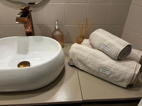 a bathroom with a white sink and towels on a counter at Lar de Noel in Rio de Janeiro