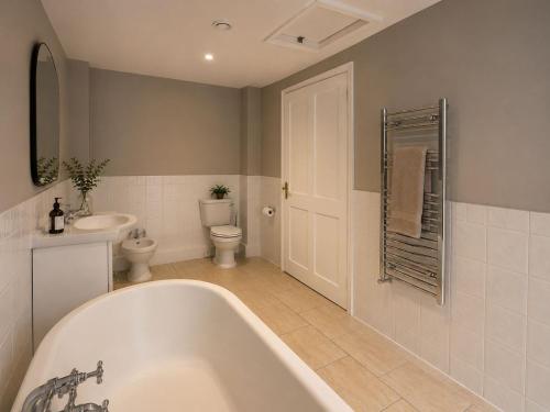 a bathroom with a tub and a toilet and a sink at Primrose Manor in Risley