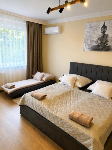 a bedroom with two beds and a large window at Harmónia Home in Miskolc