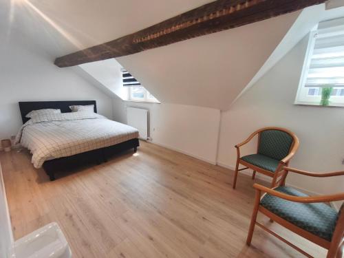 a bedroom with a bed and a chair at Sisters home in Marcinelle