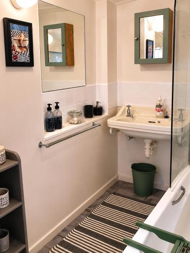 a bathroom with a sink and a tub and a mirror at The Big Tree Cottage in Graafwater