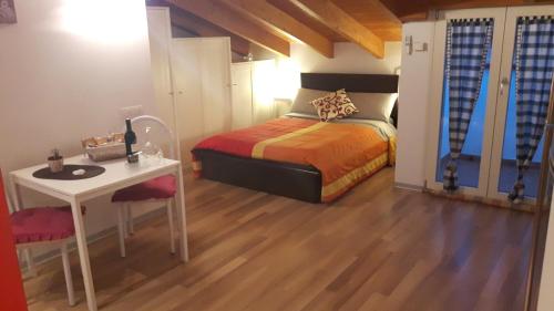 a bedroom with a bed and a table and a desk at La Mansardina in Matera