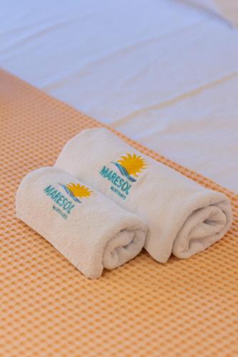 a pair of towels sitting on top of a bed at Maresol Villa in Nea Kallikrateia