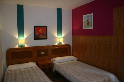 a hotel room with two beds and two lamps at Apartamentos Finca Colon in Los Quemados