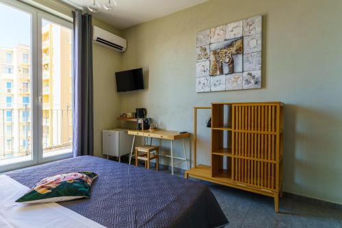 ein Schlafzimmer mit Bett, Fenster und Schreibtisch in der Unterkunft Agrigento Bed in Agrigento