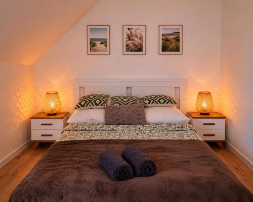 a bedroom with a large bed with two lamps at Lake House Szteklin in Szteklin