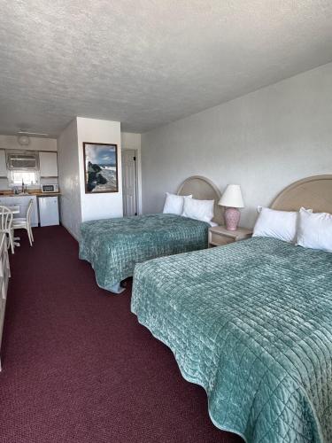 a hotel room with two beds and a kitchen at The Jetty Motel in Cape May