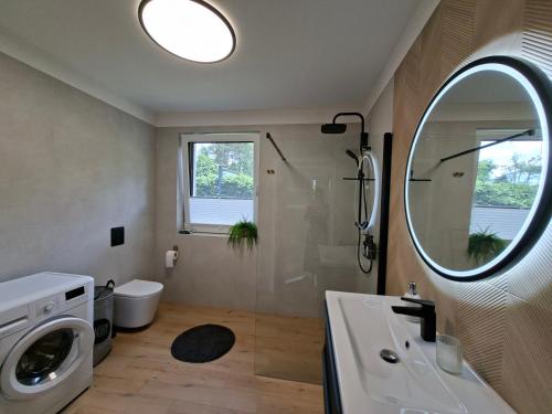 a bathroom with a shower and a sink and a mirror at Lake House Szteklin in Szteklin