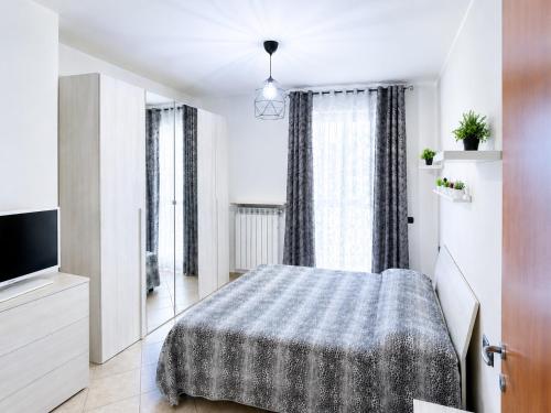 a white bedroom with a bed and a tv at Stile e comfort! in Trecate