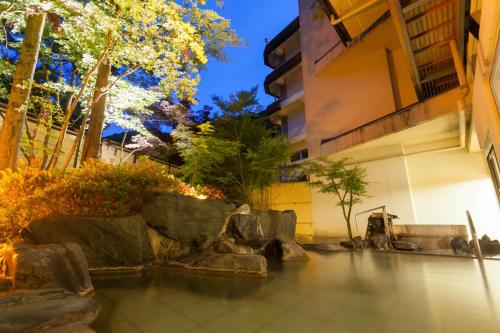 a pool of water in front of a building at Shima Grand Hotel in Nakanojo