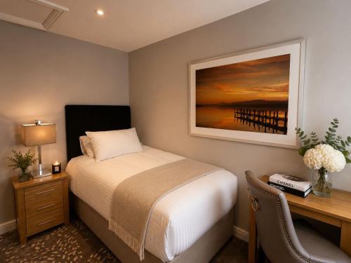 a bedroom with a bed and a desk with a desk at Primrose Manor in Risley