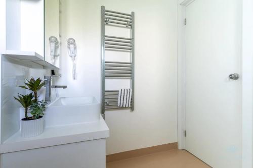 a white bathroom with a sink and a mirror at Aqua Rosa Tiszafüred 2 in Tiszafüred