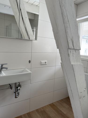 a white bathroom with a sink and a mirror at Boardinghouse Rheinfelden 4 in Rheinfelden
