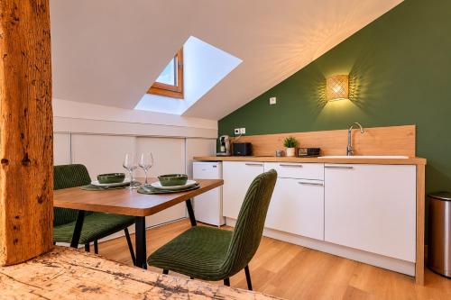 a kitchen with a table and chairs and a sink at La grande Sure & Spa in Voiron