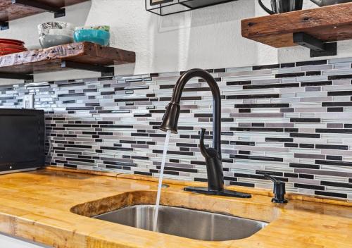 a kitchen sink with water coming out of it at Blue Heron Cottage in Galveston