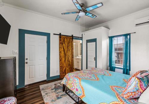 a bedroom with a bed and a ceiling fan at Blue Heron Cottage in Galveston