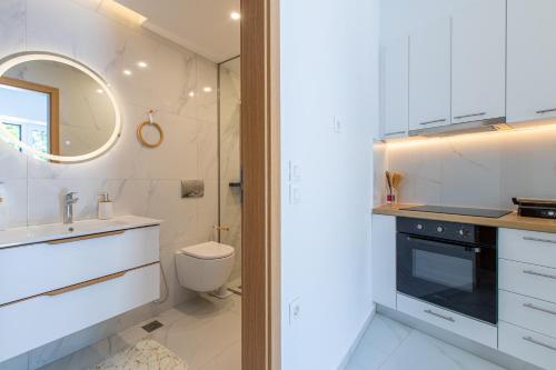 a white bathroom with a sink and a toilet at Casa Lili in Platanias