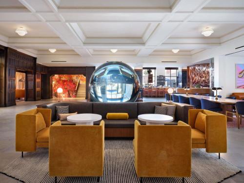 a lobby with a couch and tables and chairs at 21c Museum Hotel St Louis in Saint Louis