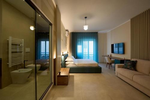 a hotel room with a bed and a bathroom at Oltremare Luxury Suites in Otranto