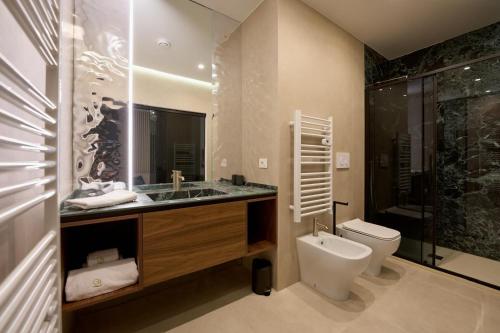 a bathroom with a toilet and a sink and a shower at Oltremare Luxury Suites in Otranto