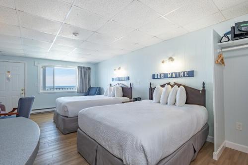 two beds in a hotel room with blue walls at Sea View Inn in Old Orchard Beach