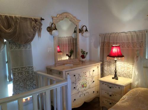 1 dormitorio con tocador, espejo y lámpara en Peristeronas house sifnos - Dove Cot sifnos, en Apollonia
