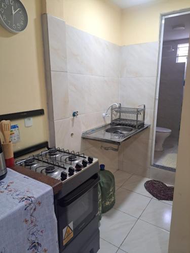 a kitchen with a stove top oven in a room at Kitnet Praia de Alagoinhas in Fortaleza