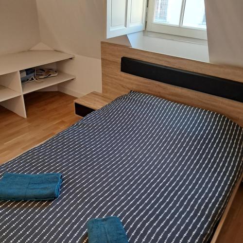 a bedroom with a bed with a blue rug at le pomerol in Château-Gontier