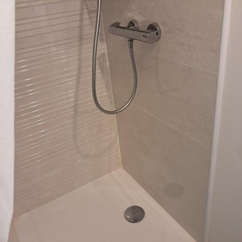 a shower with a shower head in a bathroom at le pomerol in Château-Gontier
