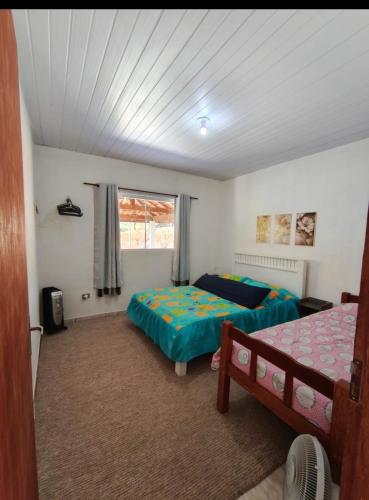 a bedroom with two beds and a window at Casa amarela in Gonçalves