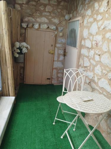 a table and a chair in front of a door at Flame Yard in Areopoli