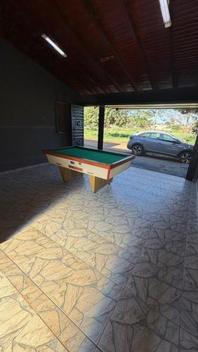 a pool table in a garage with a car at Casa queen in Campo Grande