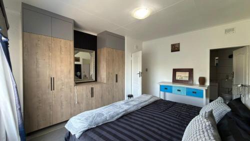 a bedroom with a bed and wooden cabinets at Polokwane Luxury Guest House in Polokwane