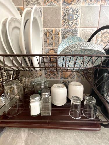a shelf with plates and glass jars and plates at Estudio #5 a 5 min del malecon in La Paz