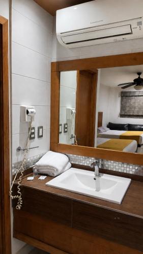 a bathroom with a sink and a mirror at Hotel Maioris El Diez Culiacan in Culiacán