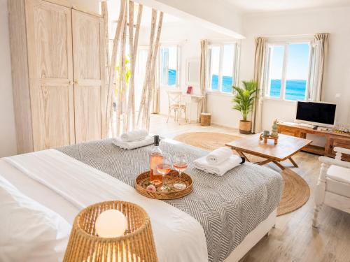 a room with two beds and a table with wine glasses at With-inn Mykonos Suites in Tourlos