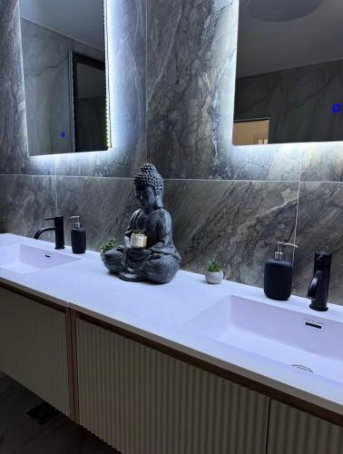 a statue sitting on top of a bathroom sink at De Papel Villa in Jankoviči