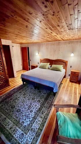 a bedroom with a bed and a wooden ceiling at Jazz House Pucon in Pucón