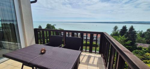 a table and chairs on a balcony with a view of the water at T8 Sunset Tihany in Tihany