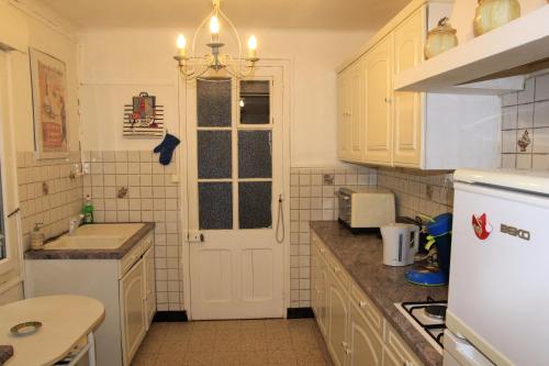 een keuken met witte kasten en een witte deur bij Studio la mésange in Mers-les-Bains