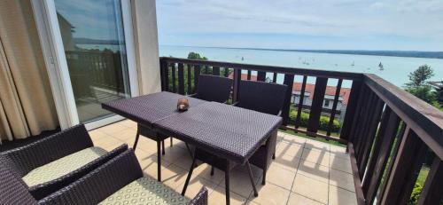 a table and chairs on a balcony with a view of the ocean at T8 Sunset Tihany in Tihany
