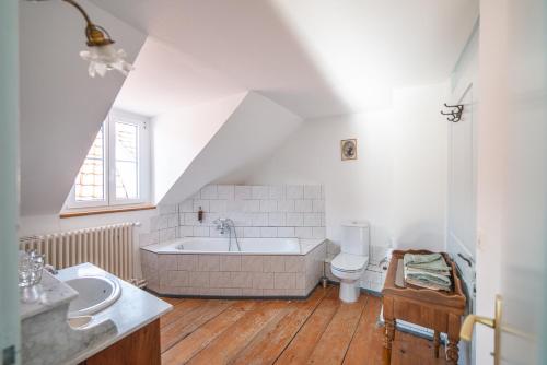 a bathroom with a tub and a toilet and a sink at Hôtel Von Bergen in La Sagne