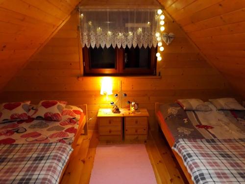a bedroom with two beds and a window with lights at TLdomki in Radęcin