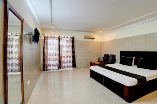 a bedroom with a bed and a television in it at Hotel O Meera in Chennai