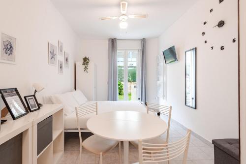 a white living room with a white table and chairs at Beachfront Studio Free Parking-Pool 50m from Sea in Chioggia