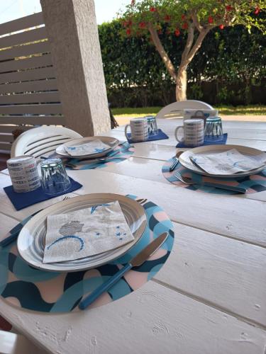 a table with plates and napkins on top of it at Summer Rooms Caucana in Punta Secca